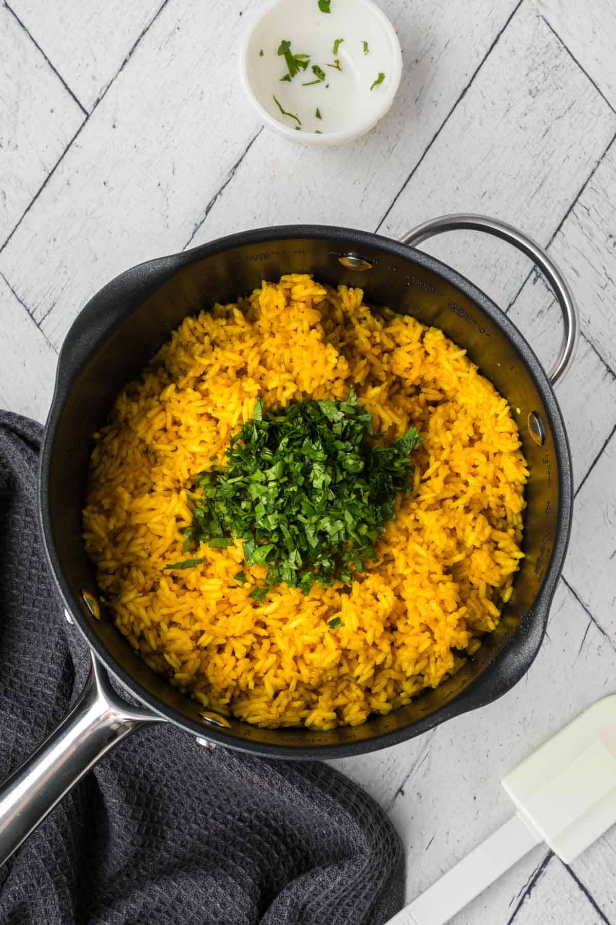 Cooked yellow rice topped with chopped cilantro