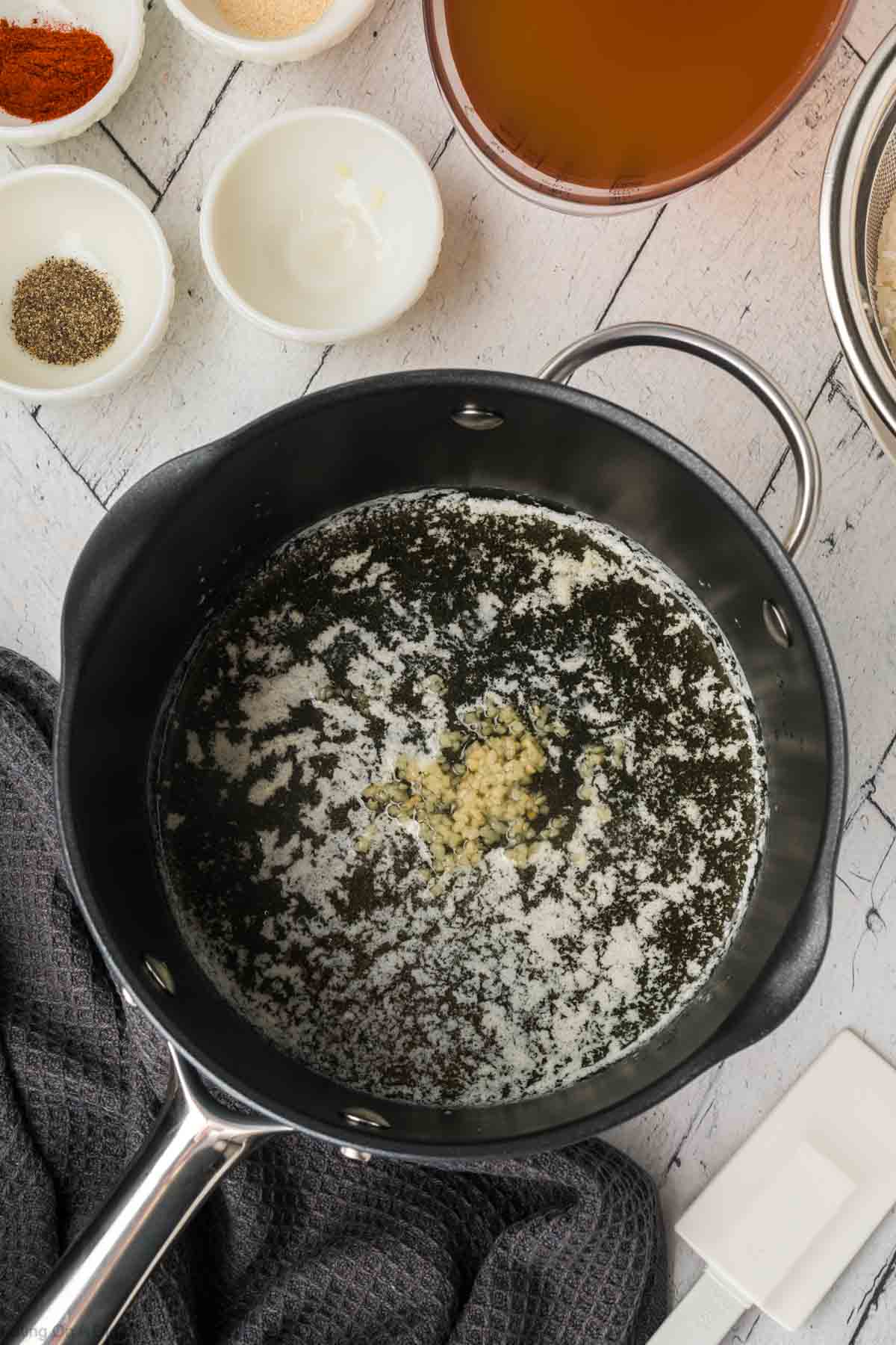 Melting butter with minced garlic in a large saucepan