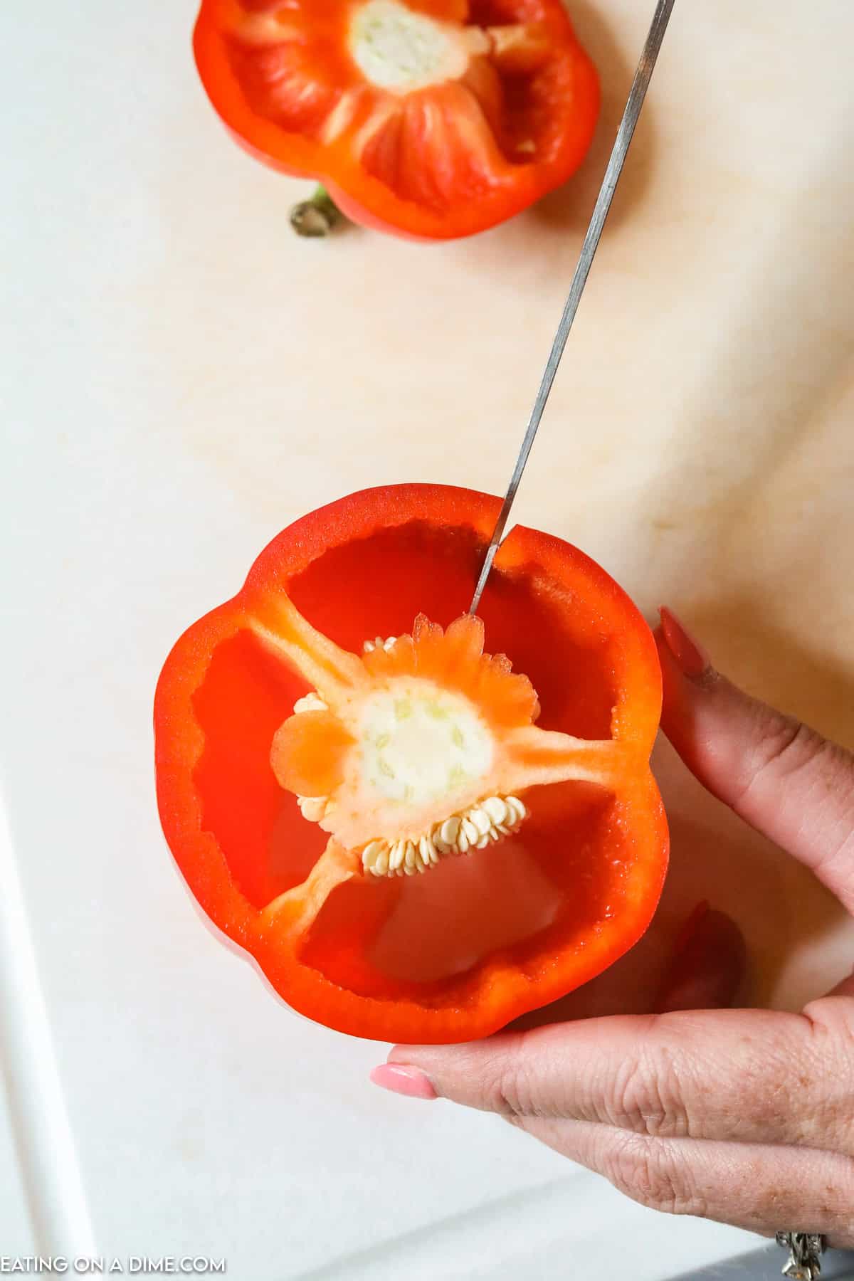 Slicing the red bell pepper on a cutting board with a knife