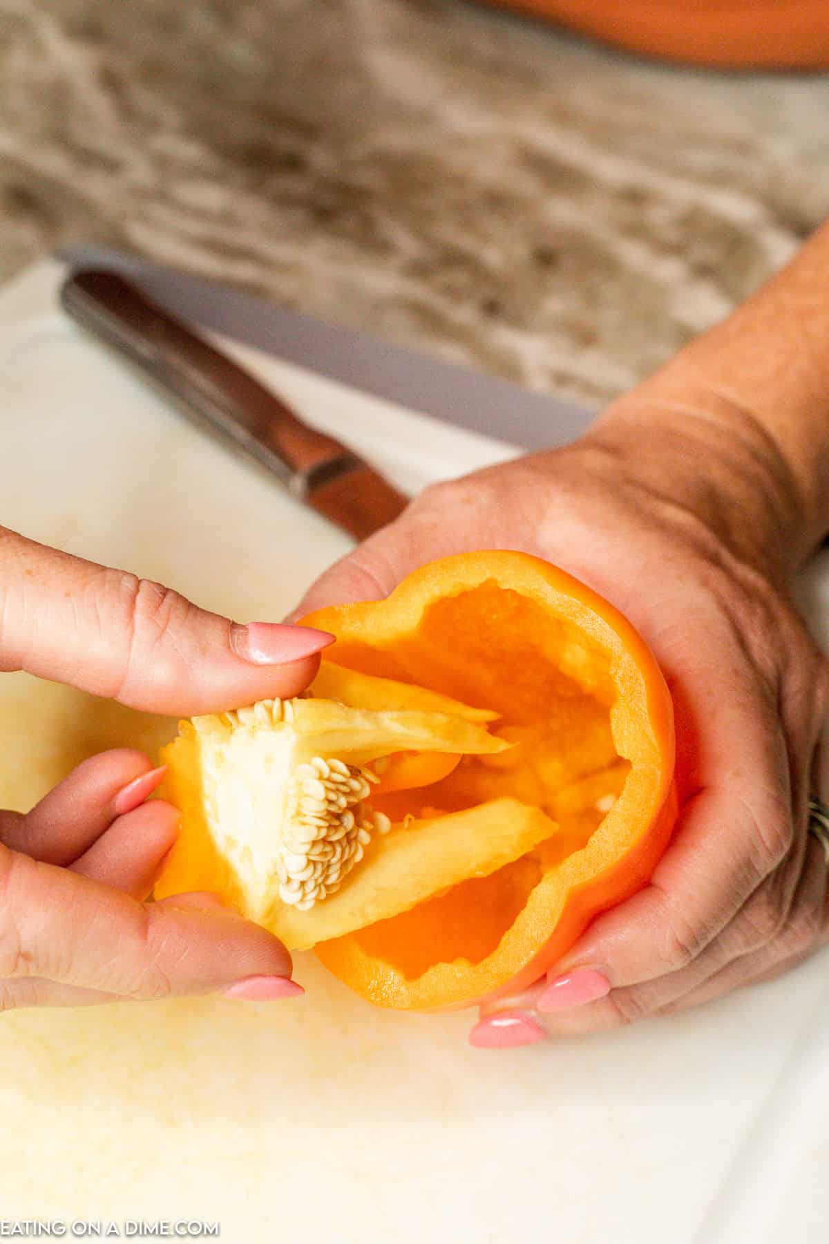 Removing the inside of the orange bell pepper 