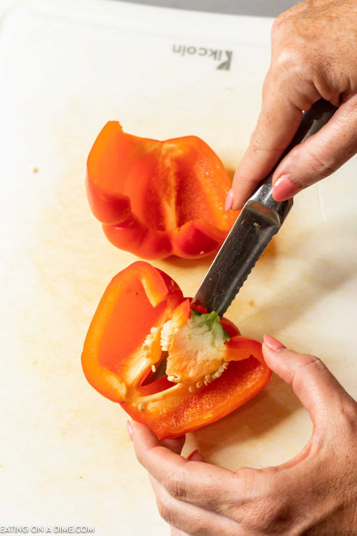 Cutting the inside of the bell pepper with a knife 