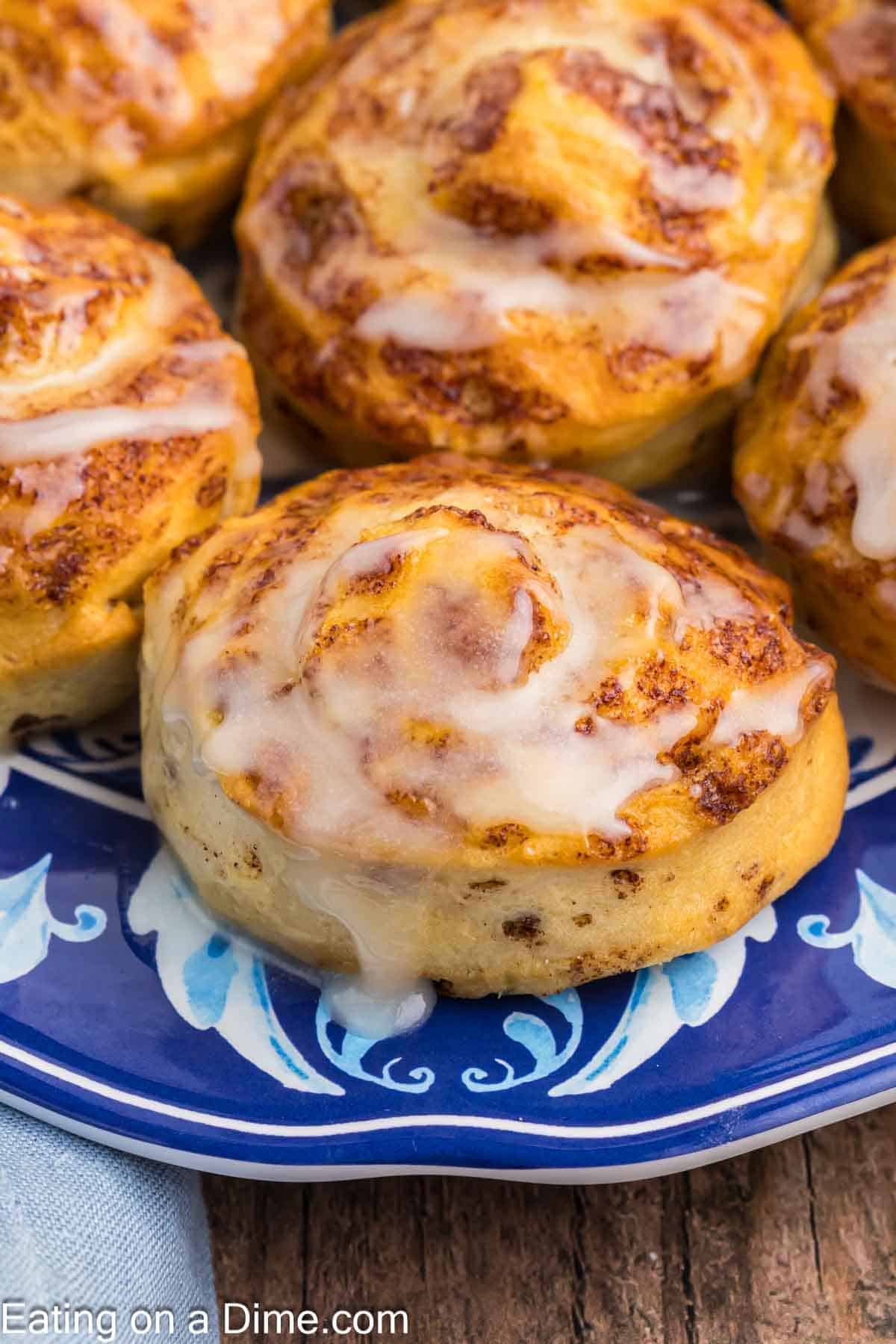 Cinnamon rolls topped with icing on a plate