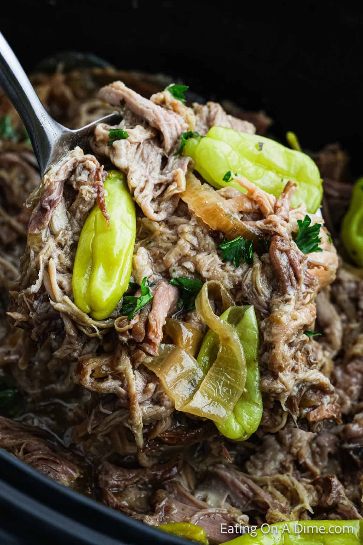 Ladle of shredded pork and pepperoncini peppers