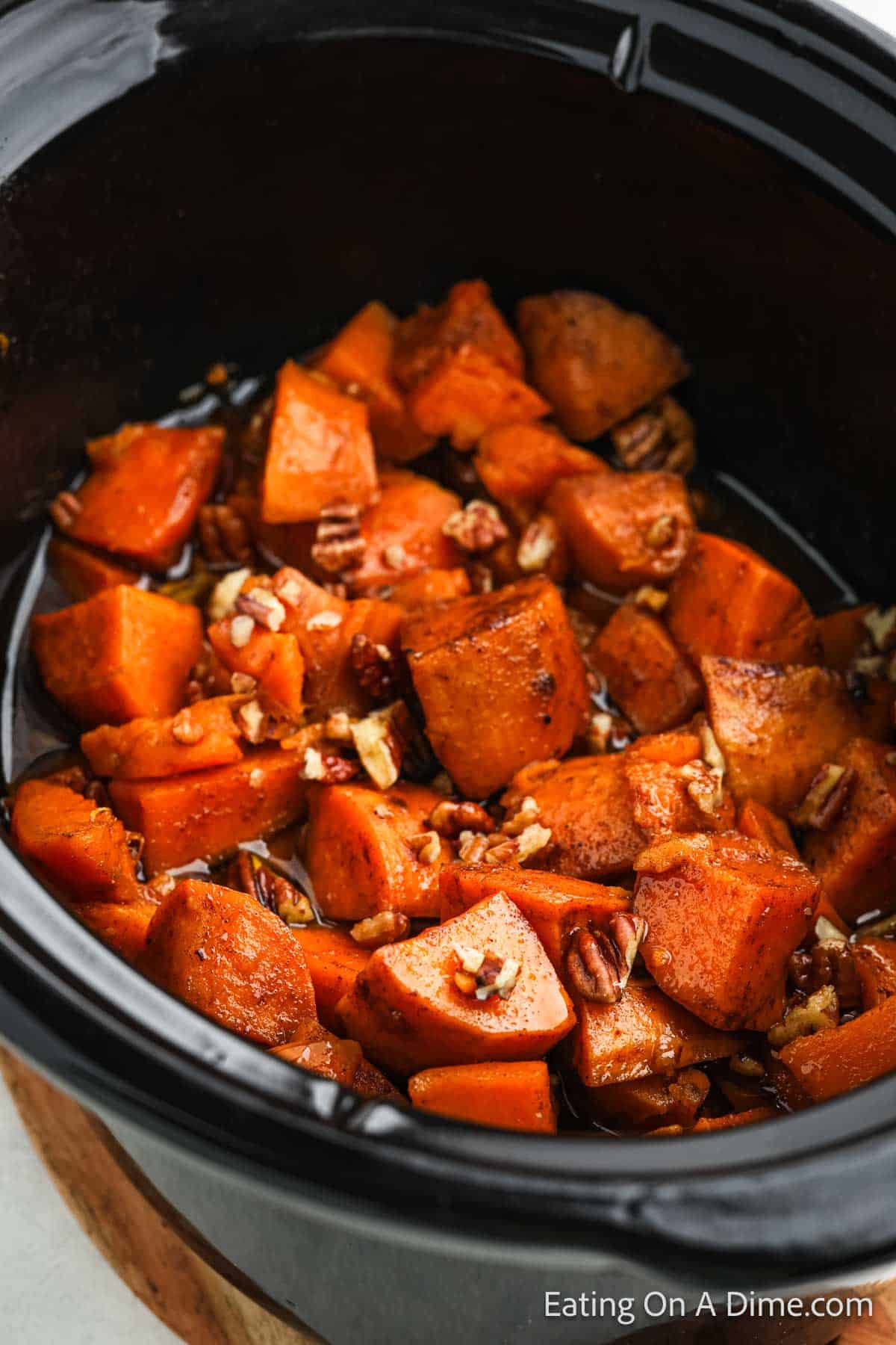 Candied Sweet Potatoes in the slow cooker topped with chopped pecans