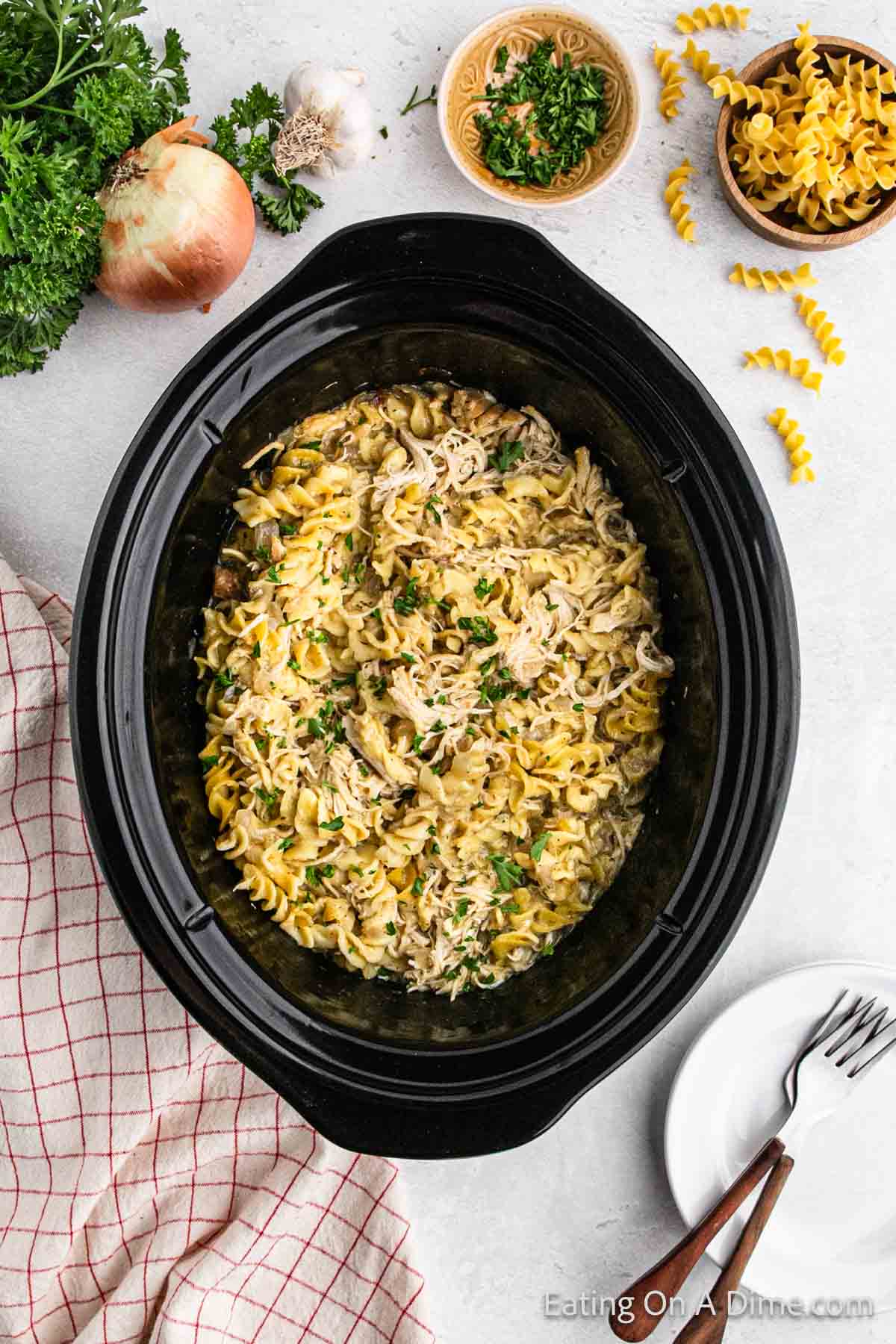 Shredded Chicken and Rotini Noodles in the slow cooker topped with parsley 