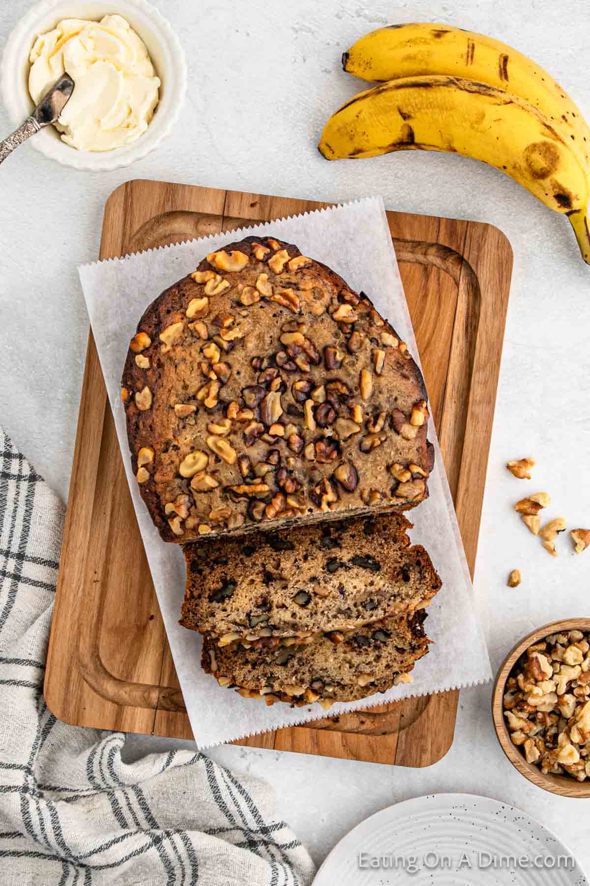 Banana Bread on a cutting board lined with parchment paper sliced