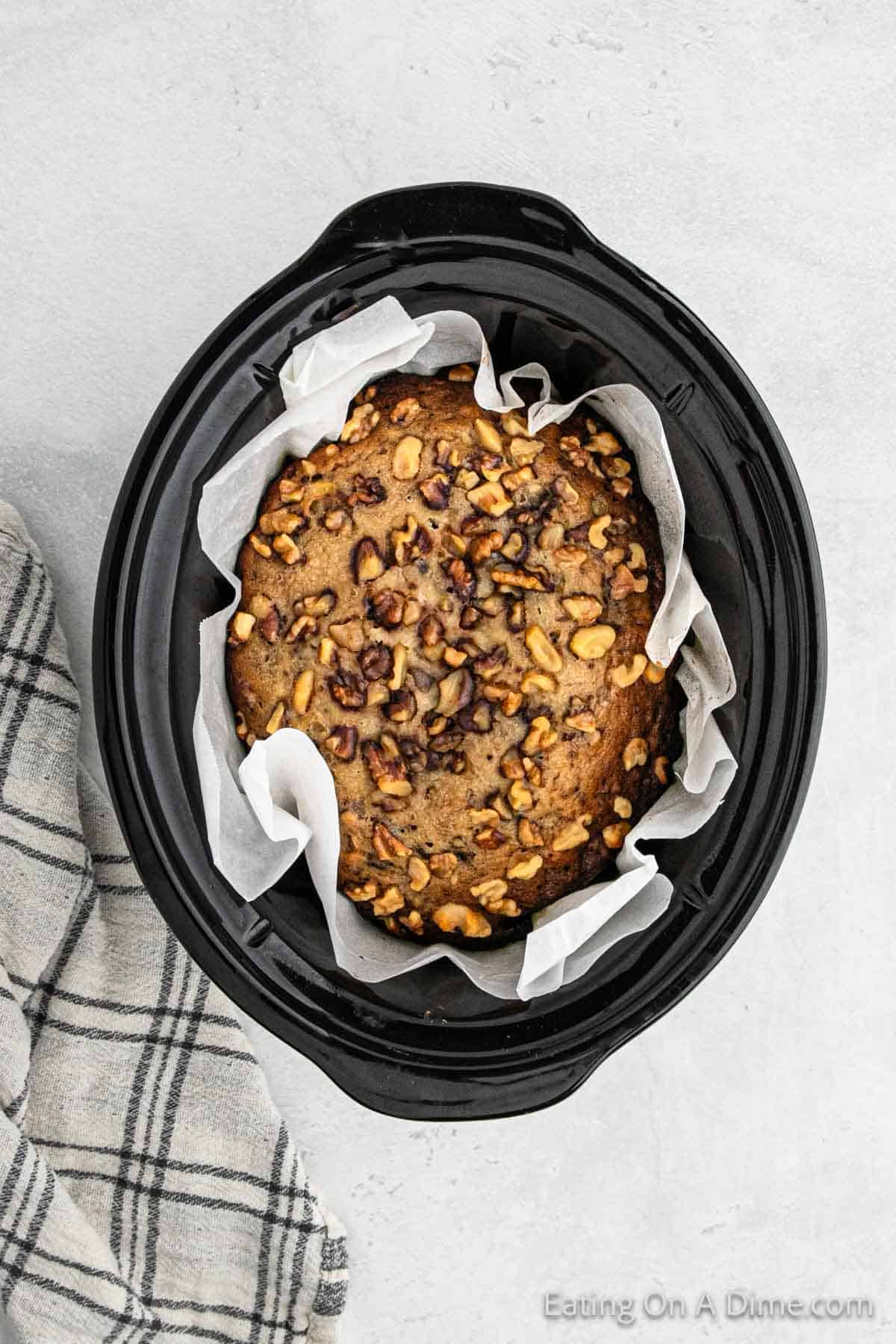 Cooked Banana Bread in the slow cooker lined with parchment paper