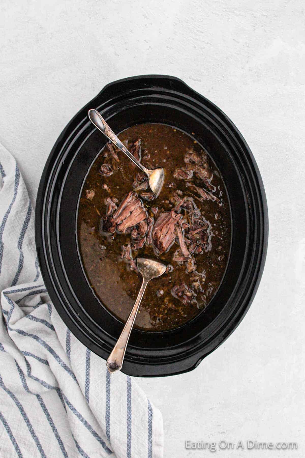 Shredding the beef with two fork in the slow cooker 