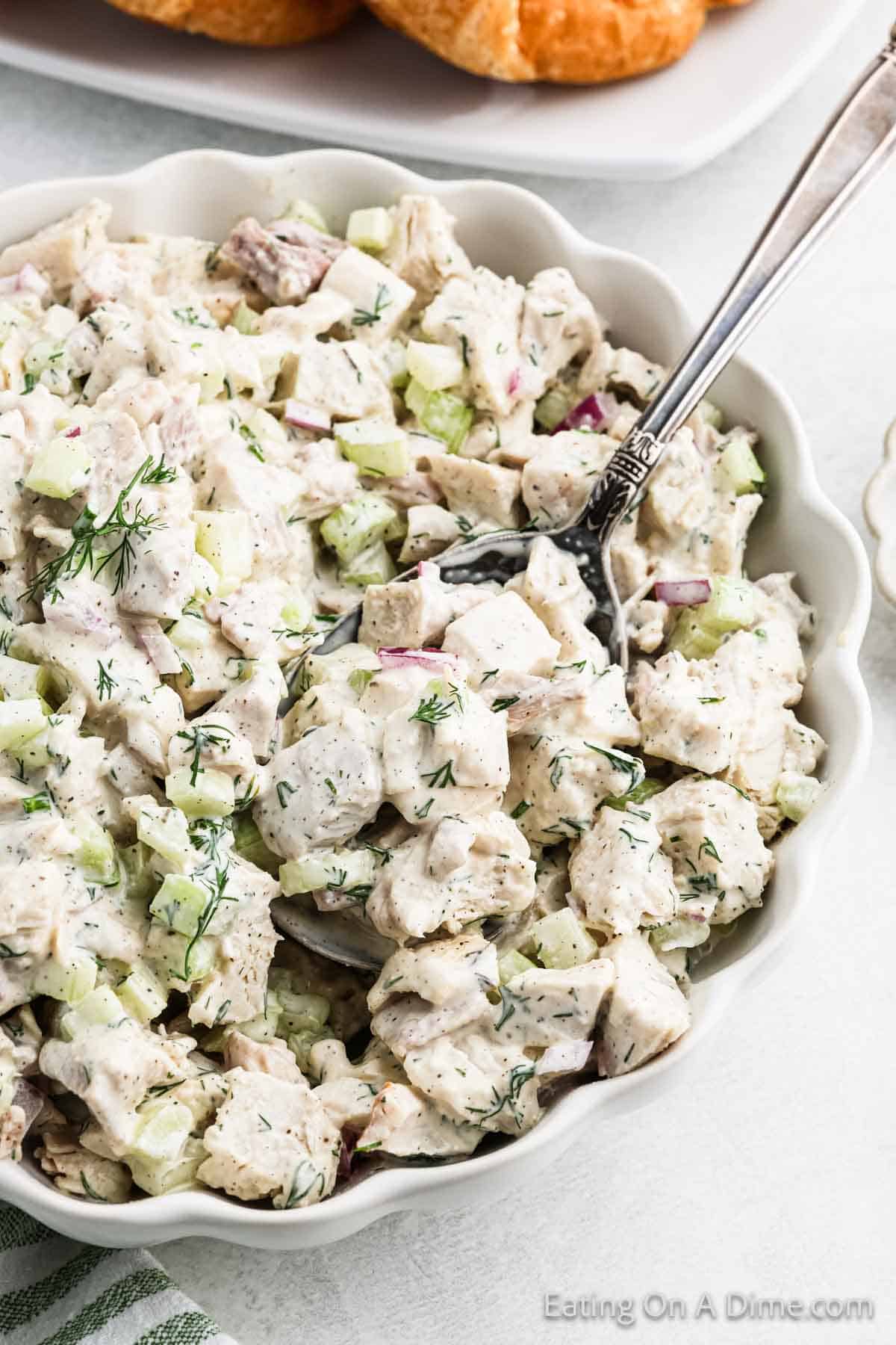 Turkey Salad in a large white bowl with a silver spoon with a serving 