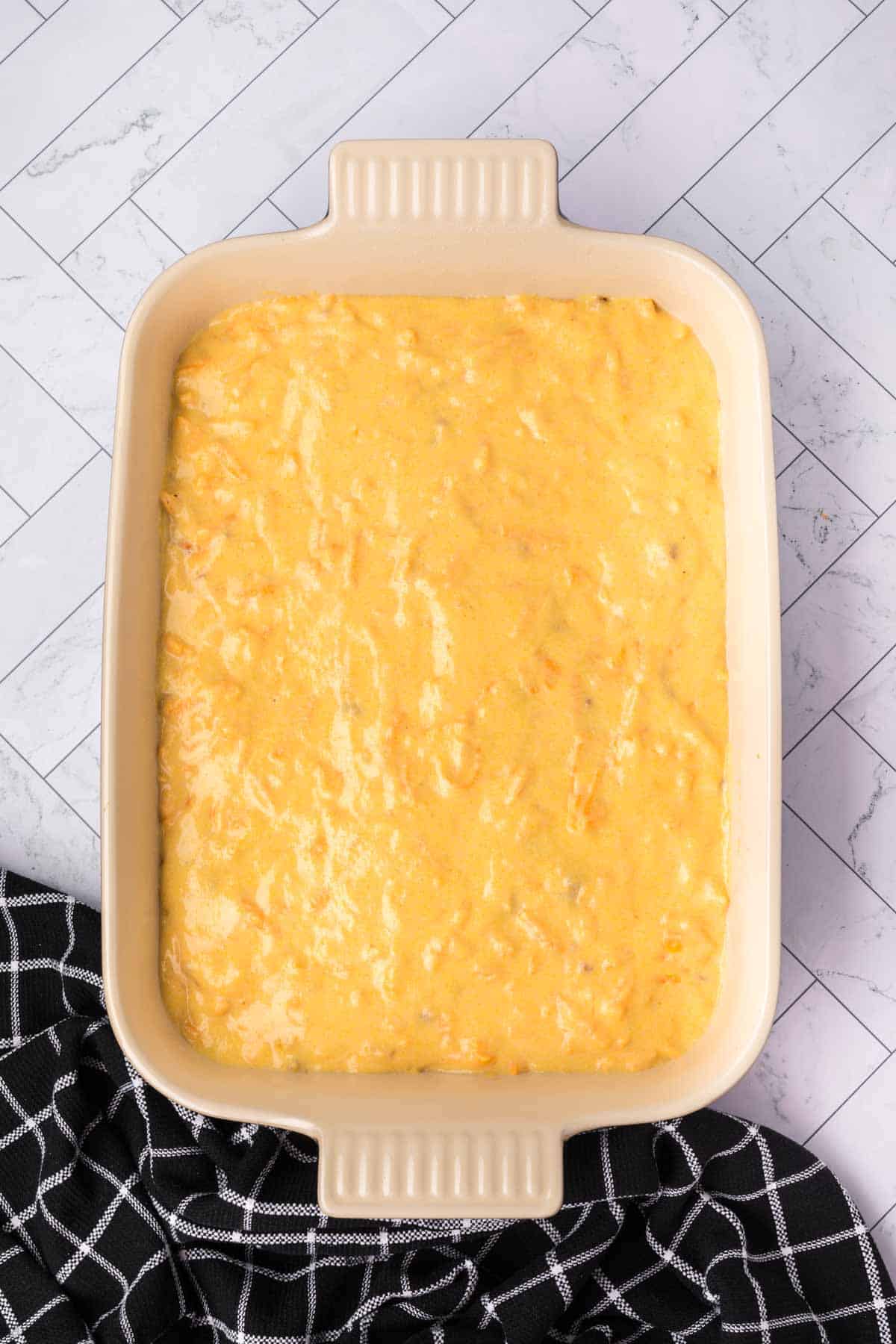 Spreading the cornbread batter in a baking dish