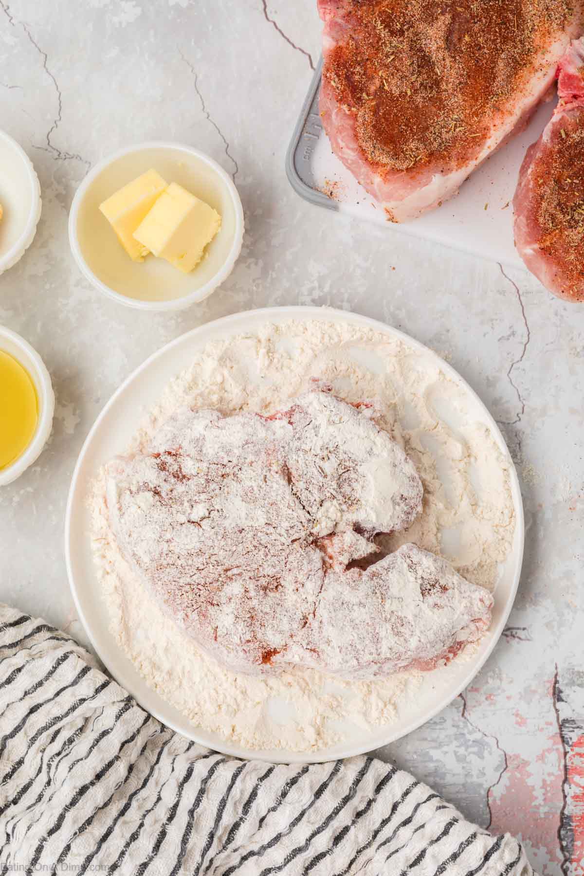 Placing the pork chops in flour mixture 