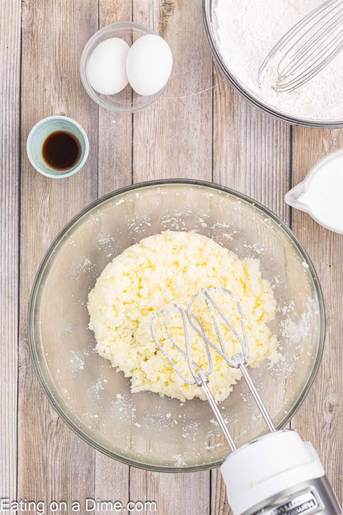 Butter and sugar blended together in a bowl with a mixer