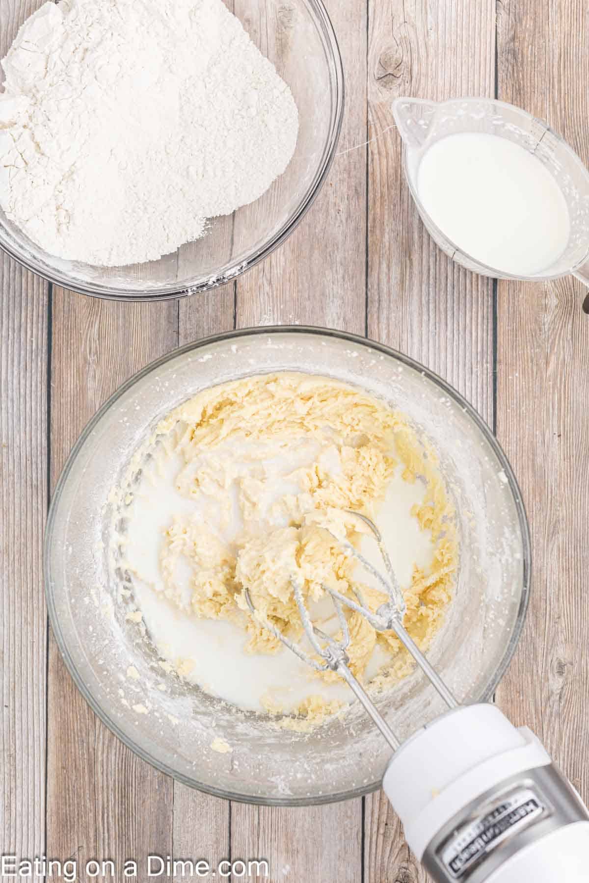 Flour mixture and cream added to the butter mixture in a bowl