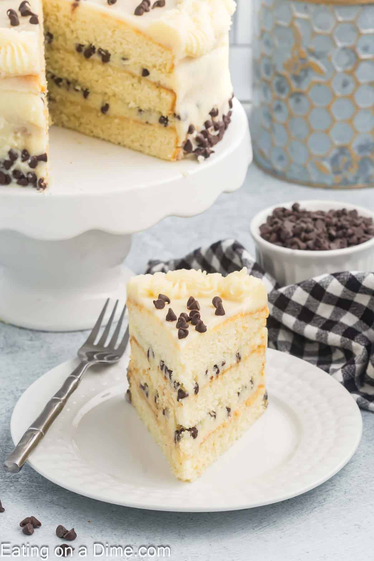 Slice of Cannoli Cake on a plate with a Cannoli Cake on a cake pan