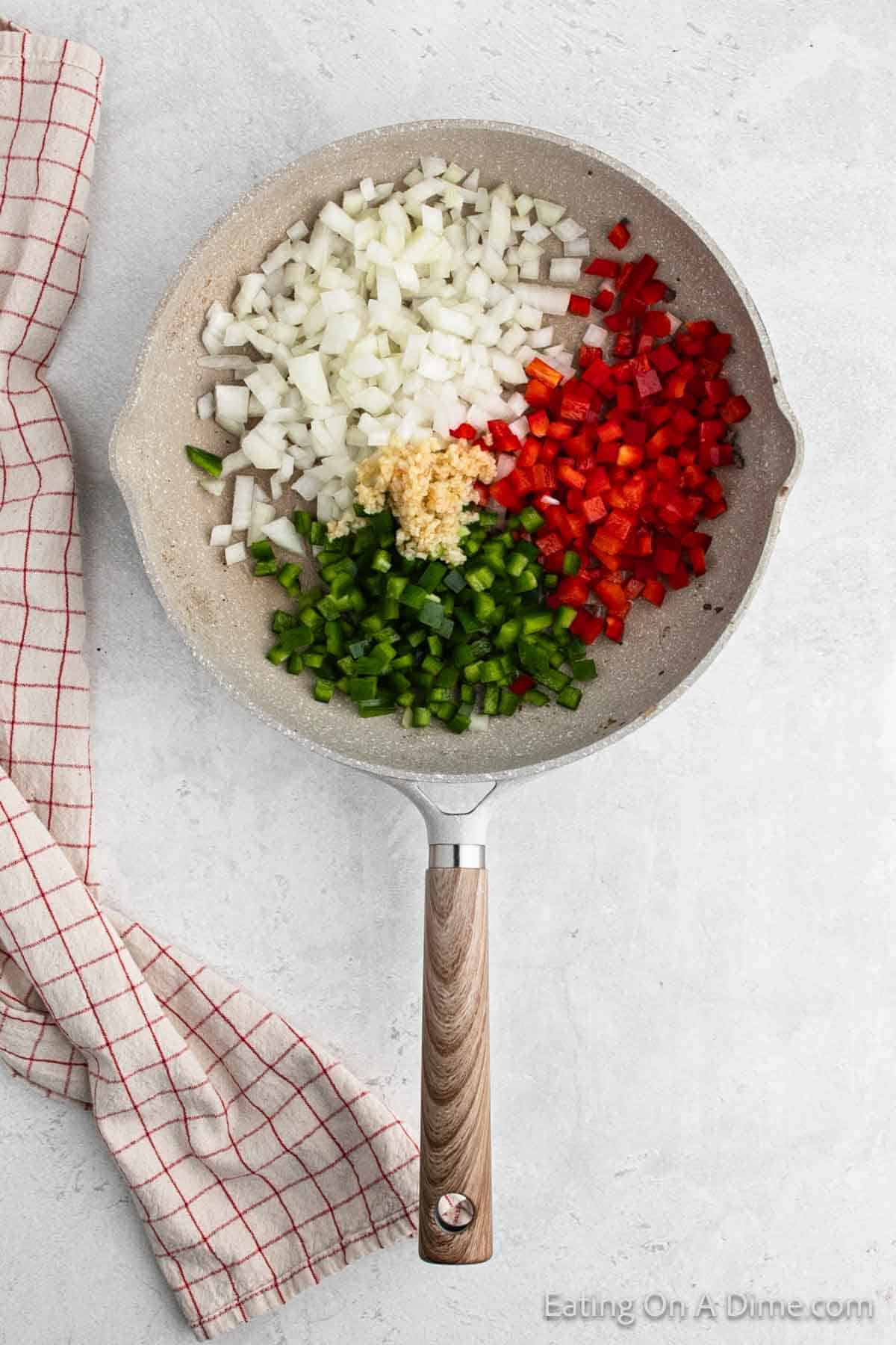 Chopped onions, red bell pepper, green bell pepper and minced garlic in a large skillet