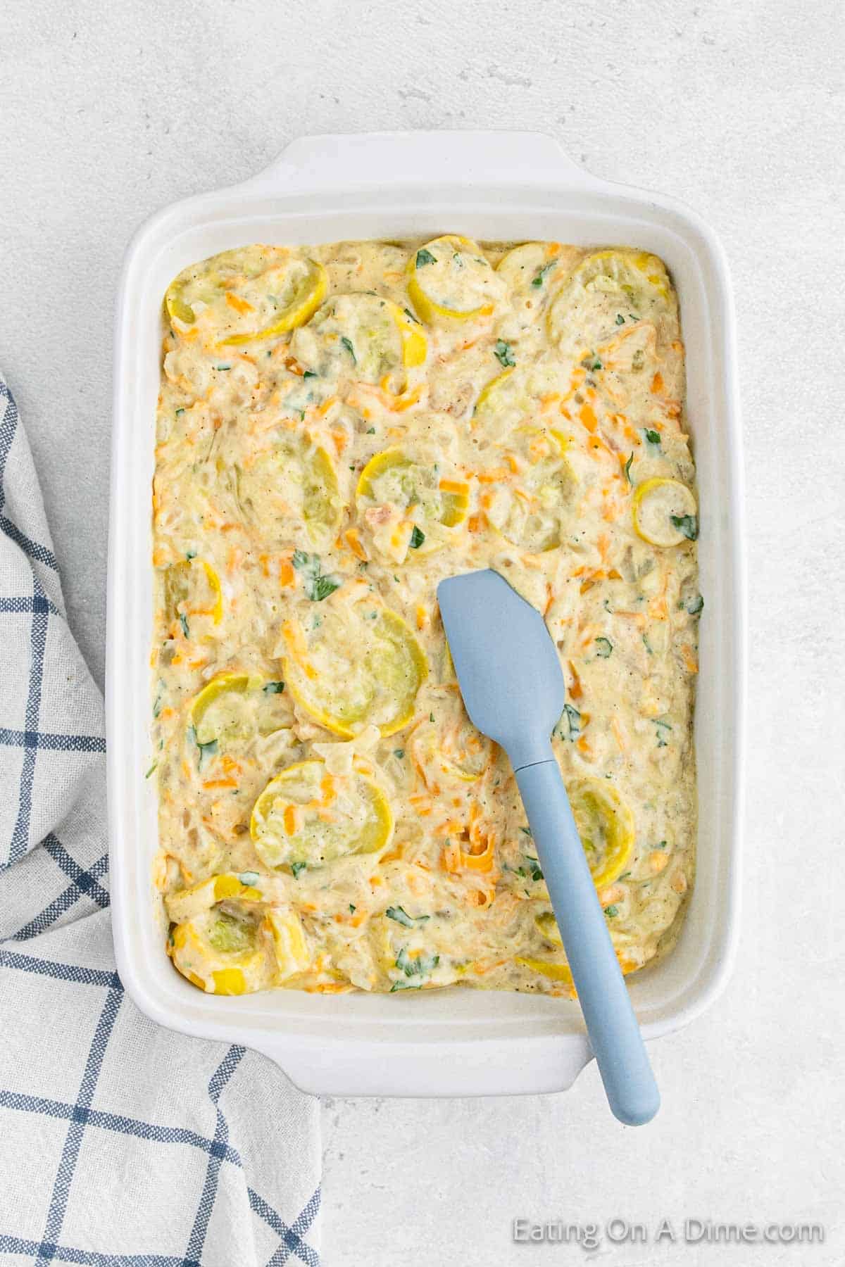 Spreading the squash in the baking dish with a spatula