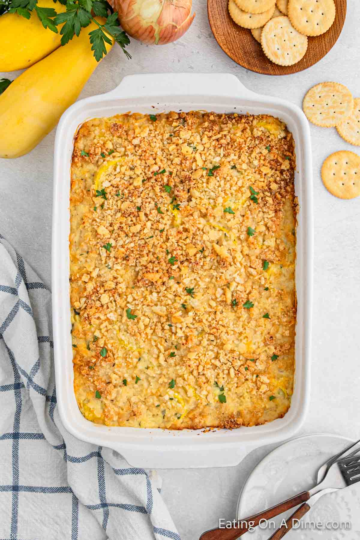 Baked Squash Casserole with crackers on the side and fresh yellow squash