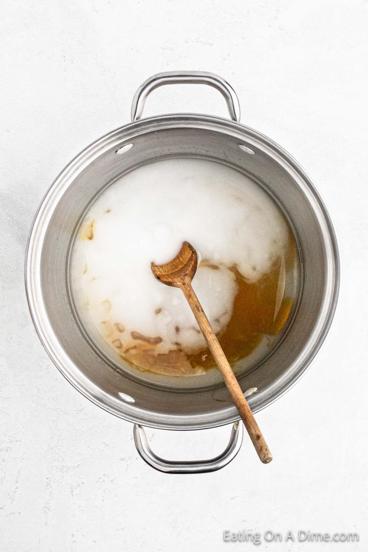 Water, salt, sugar and honey mixed together in a large pot with a wooden spoon