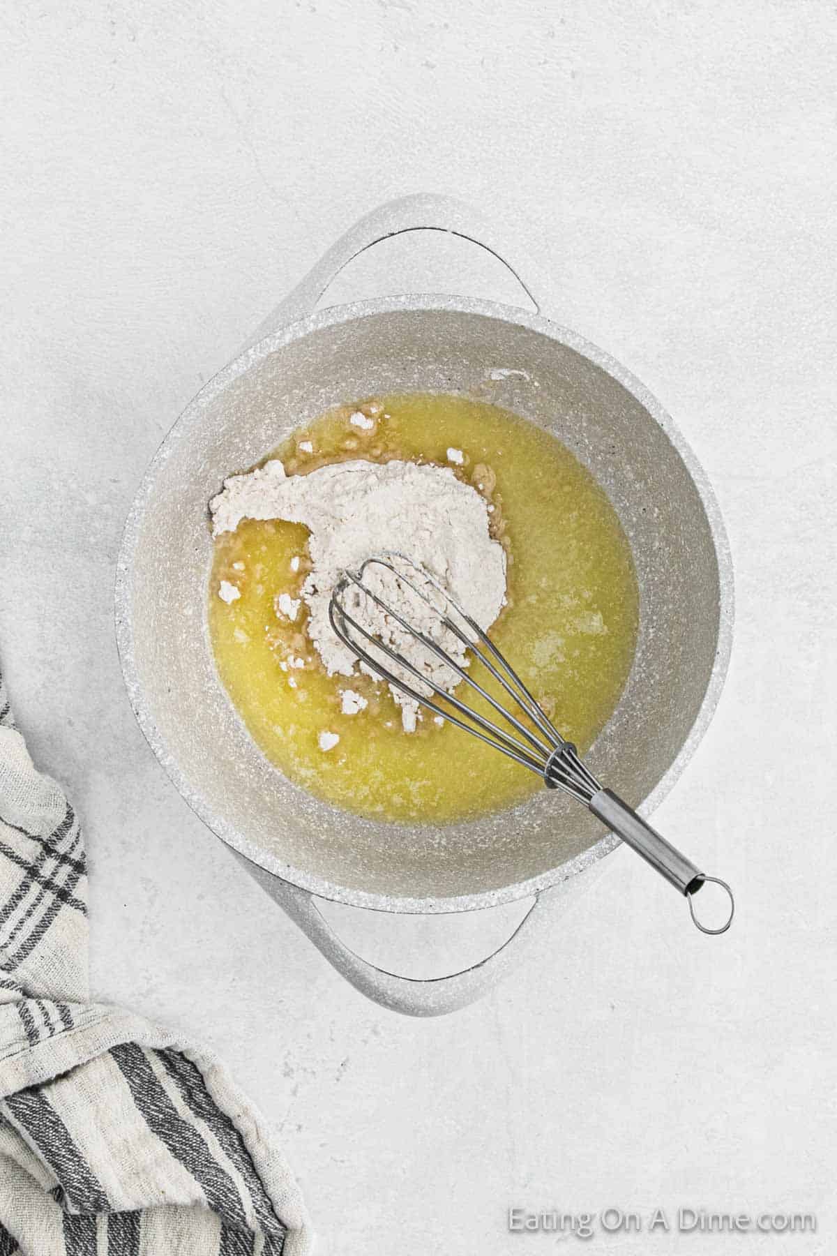 Melting butter and flour in a large pot with a whisk