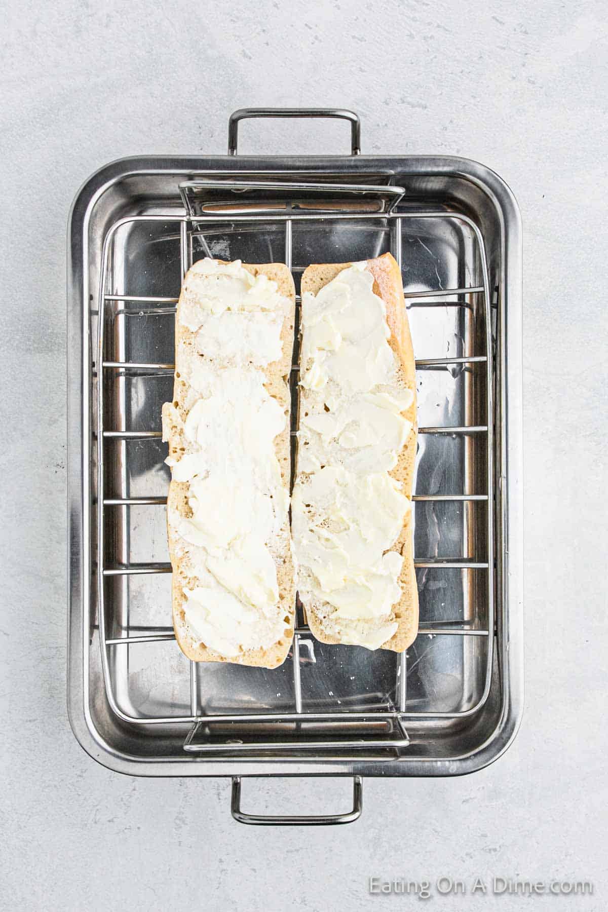 Placing the butter ciabatta bread on the roasting pan