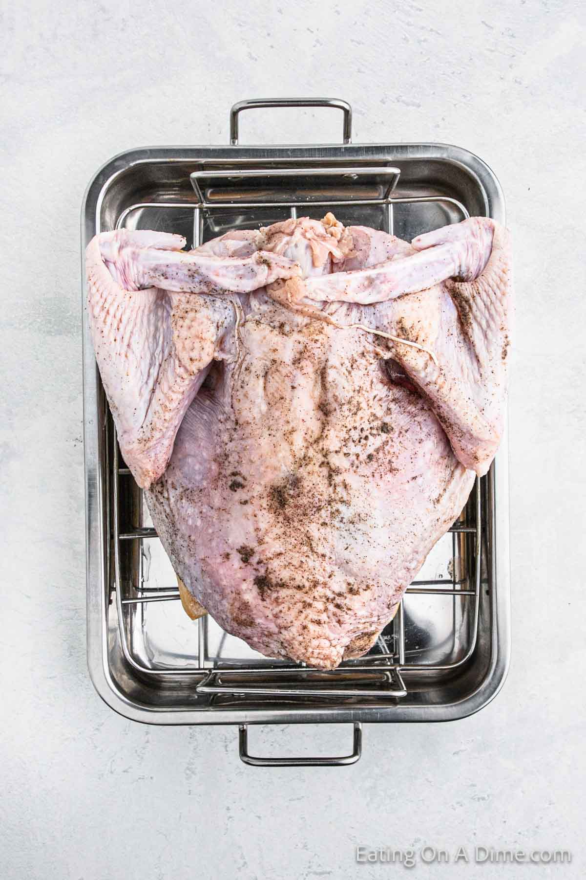 Upside Down Seasoned whole turkey on the roasting pan