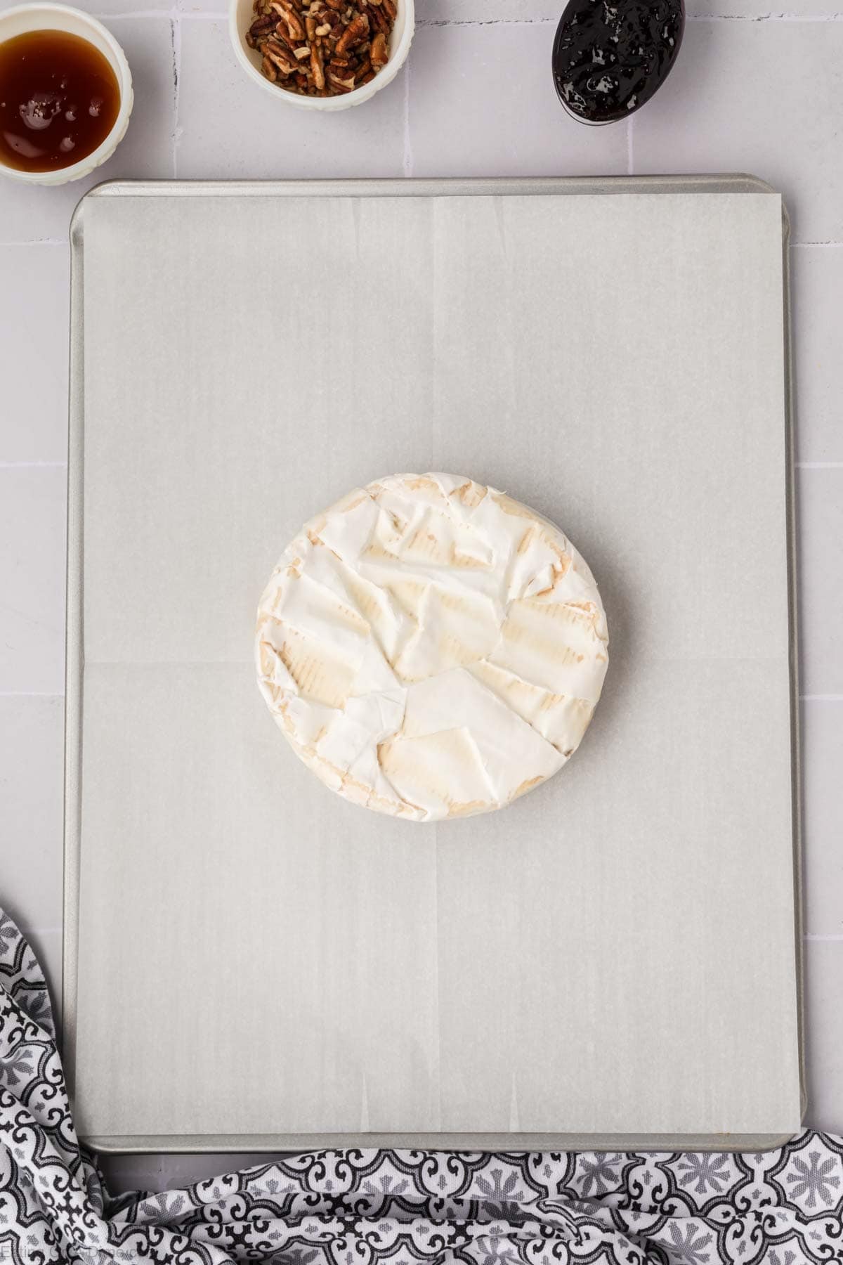 Wheel of Brie on a baking sheet lined with parchment paper