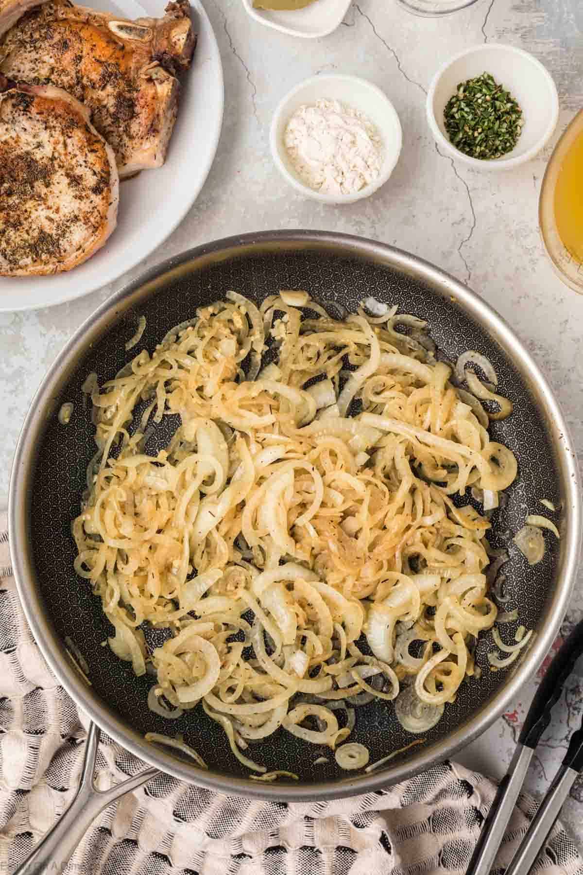 Caramelized in a skillet with a plate of pork chops on the side 