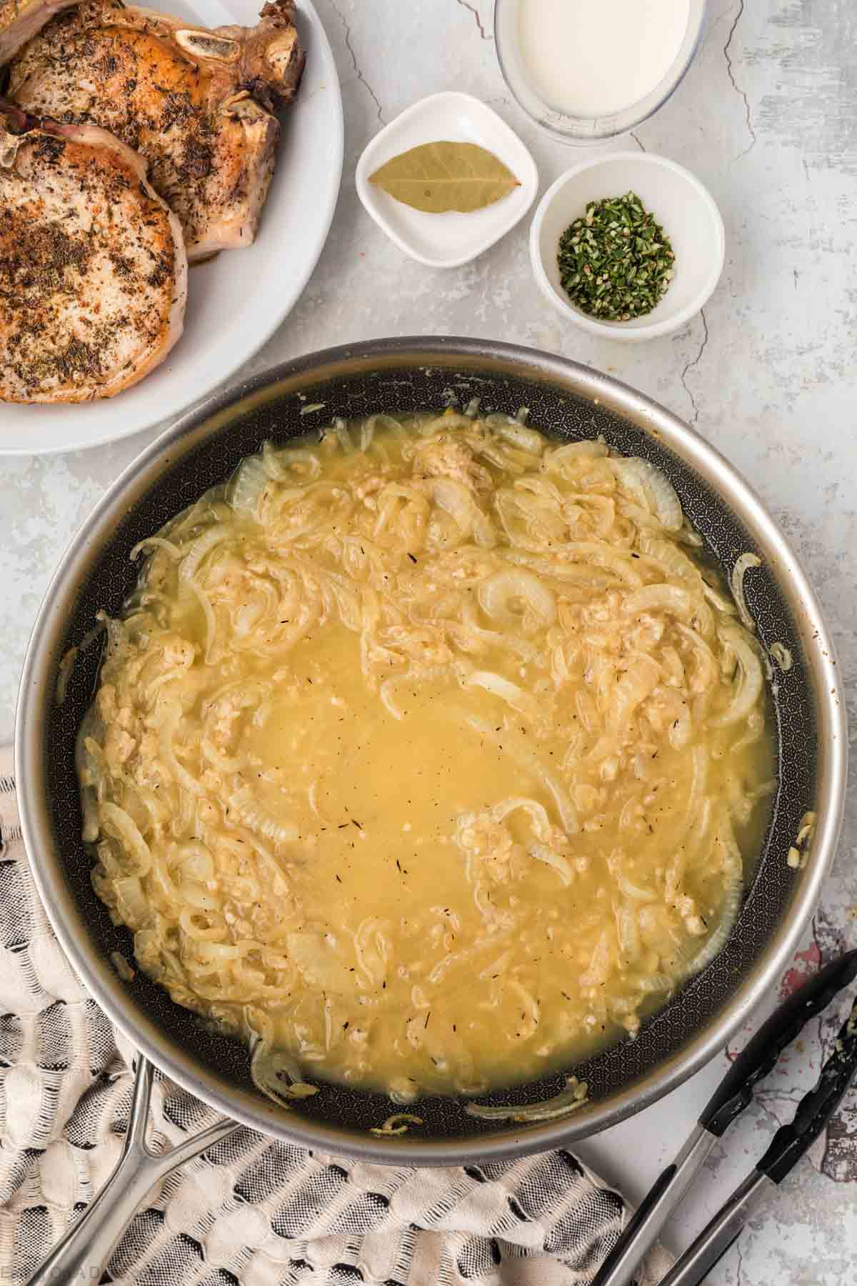 Chicken broth poured into skillet with caramelized onions