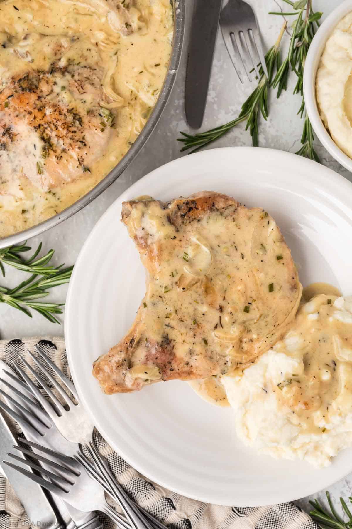 Smothered pork chops on a plate with mashed potatoes and gravy