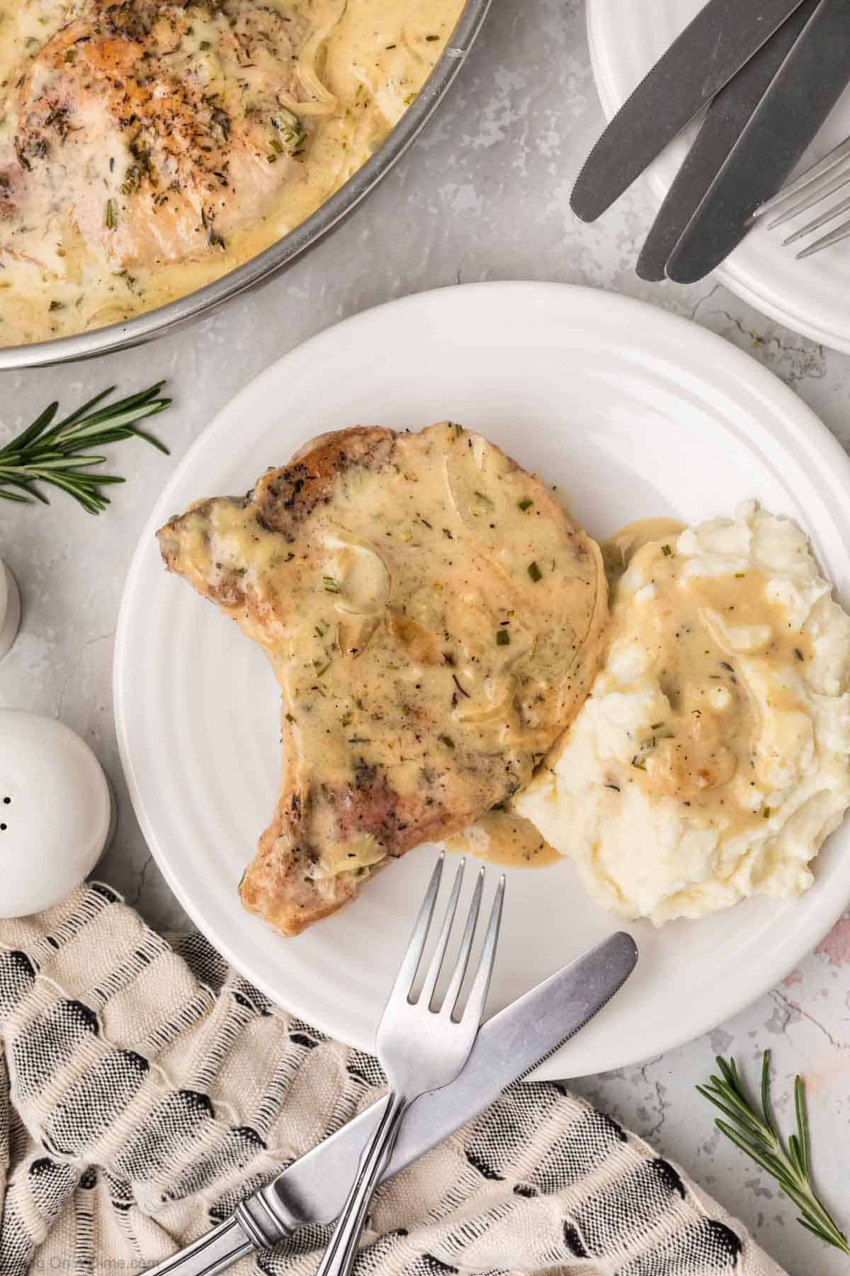 Smothered pork chops on a plate with mashed potatoes and gravy