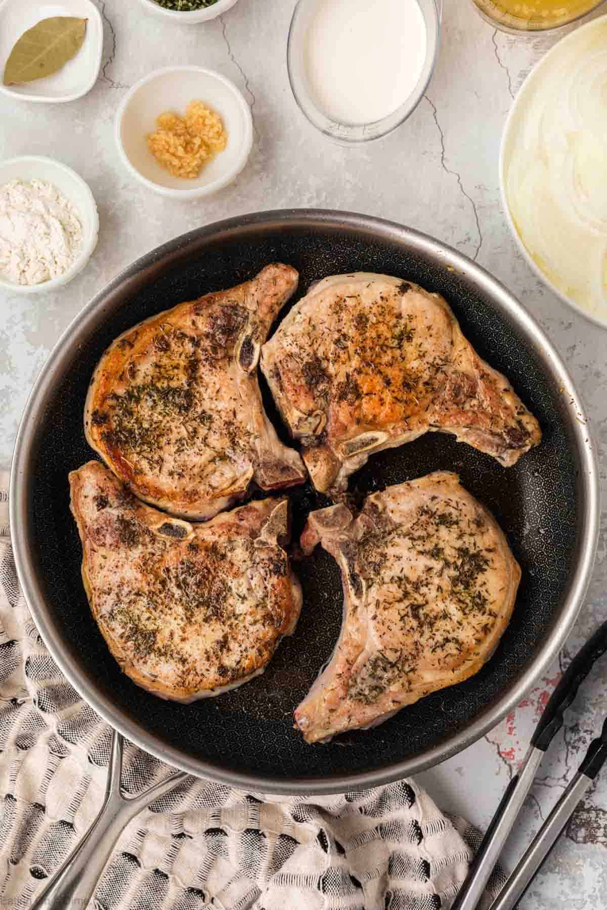 Golden Brown pork chops in a skillet 