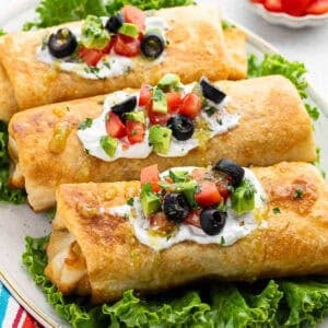 Enjoy three crispy chimichangas topped with sour cream, diced tomatoes, avocado, olives, and cilantro, served on a bed of lettuce as part of Meal Plan 33.