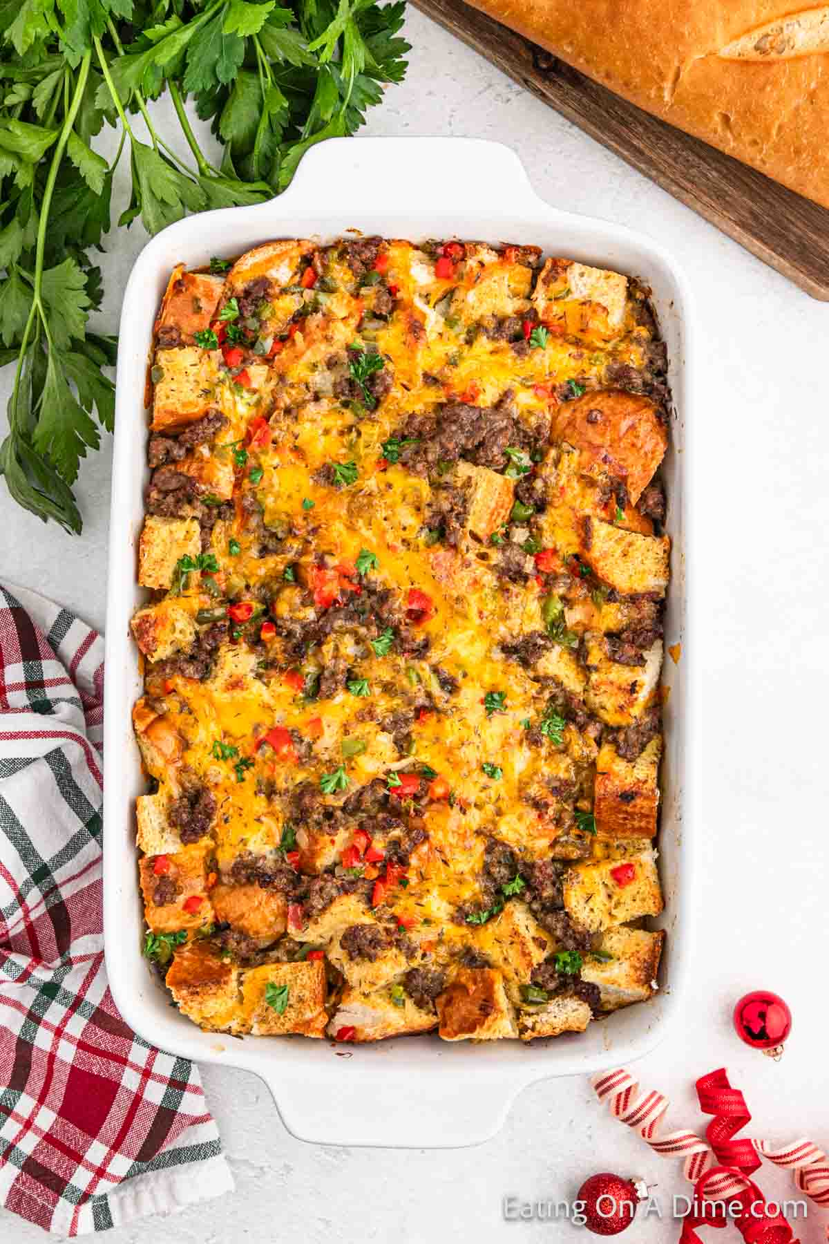 Breakfast casserole in a casserole dish with cooked sausage, diced bread and red bell peppers and baked golden brown