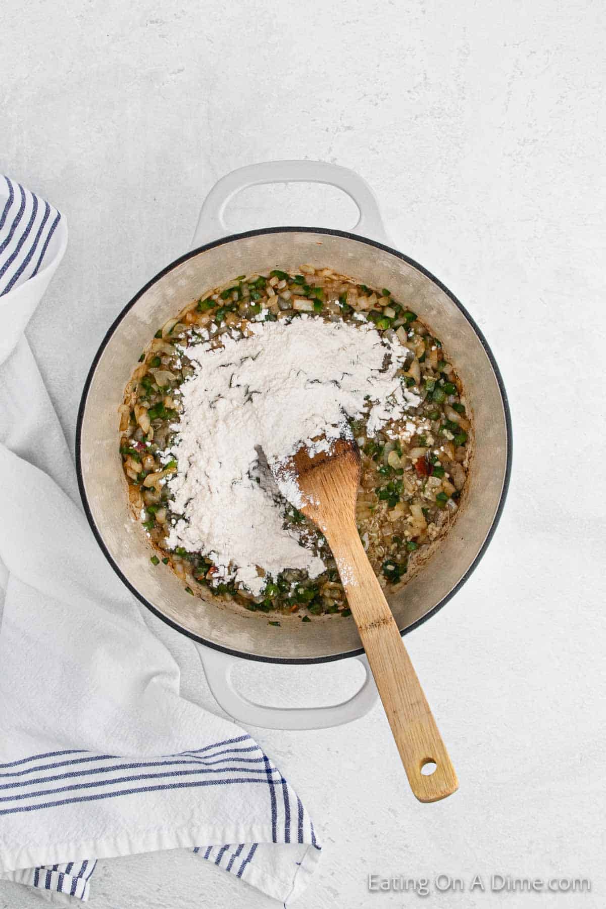 Cooked chopped veggies in a large pot with flour on top