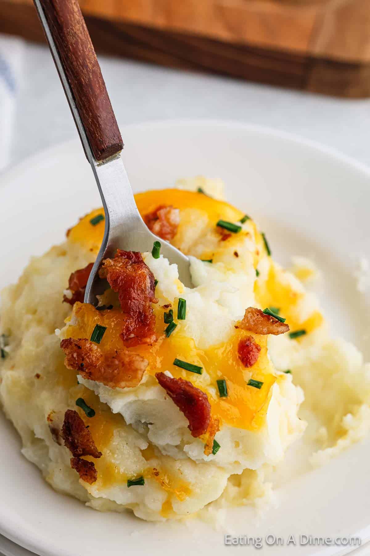 Serving of mashed potato casserole on a plate with a spoon