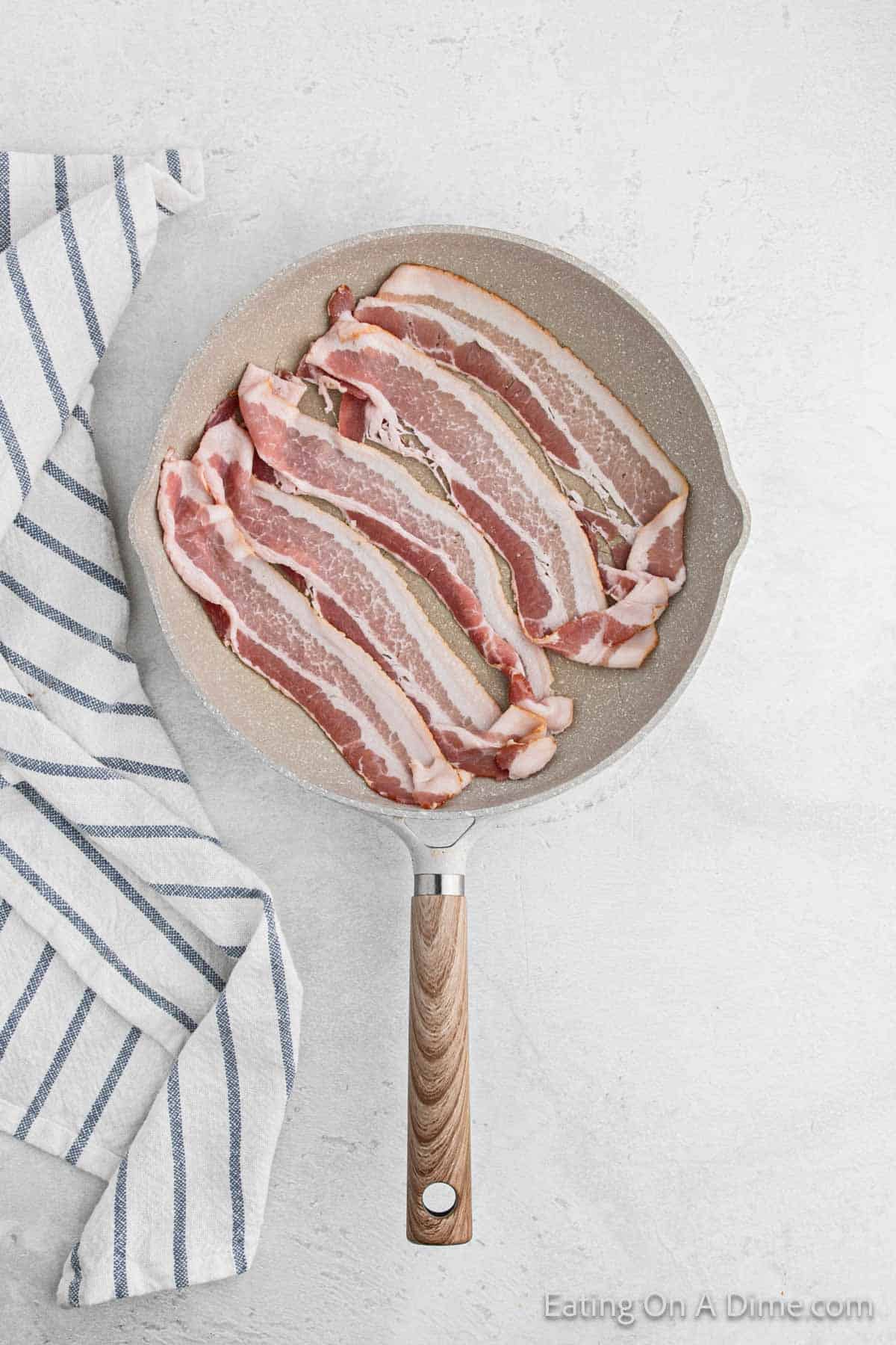 Frying bacon strips in a skillet