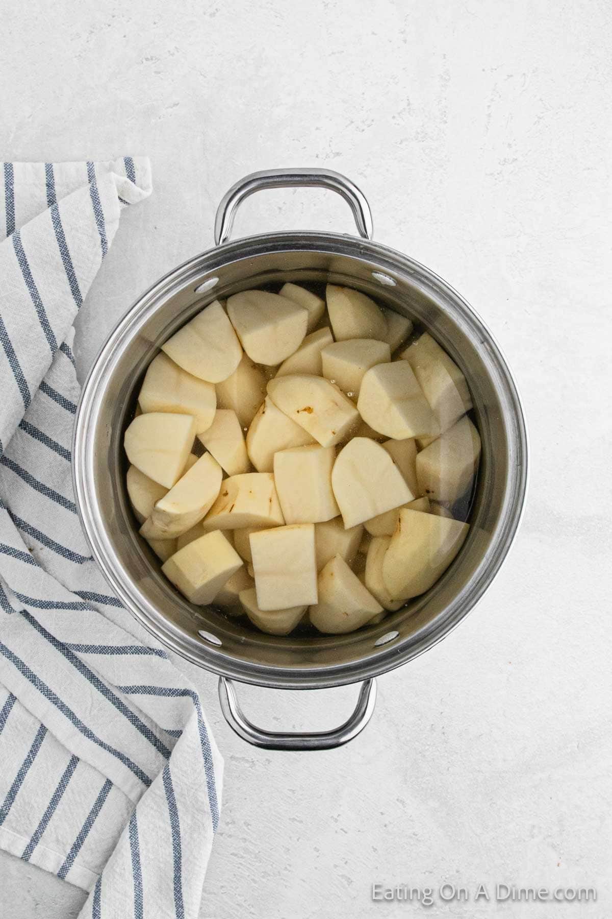 Quartered potatoes in a large pot with water