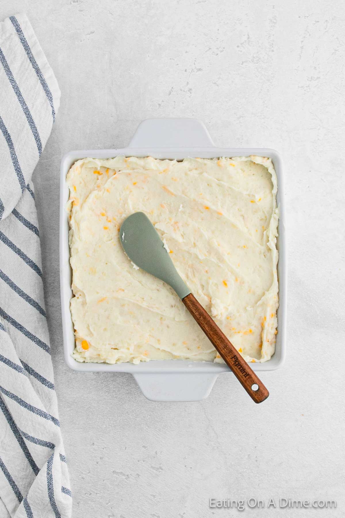 Spreading mashed potatoes in a casserole dish 