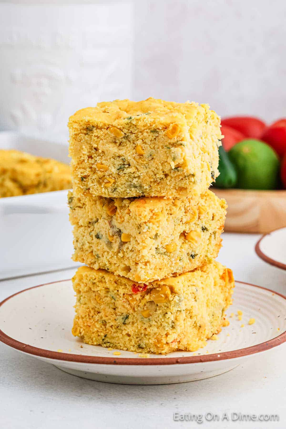 Square slices of cornbread stacked on a plate