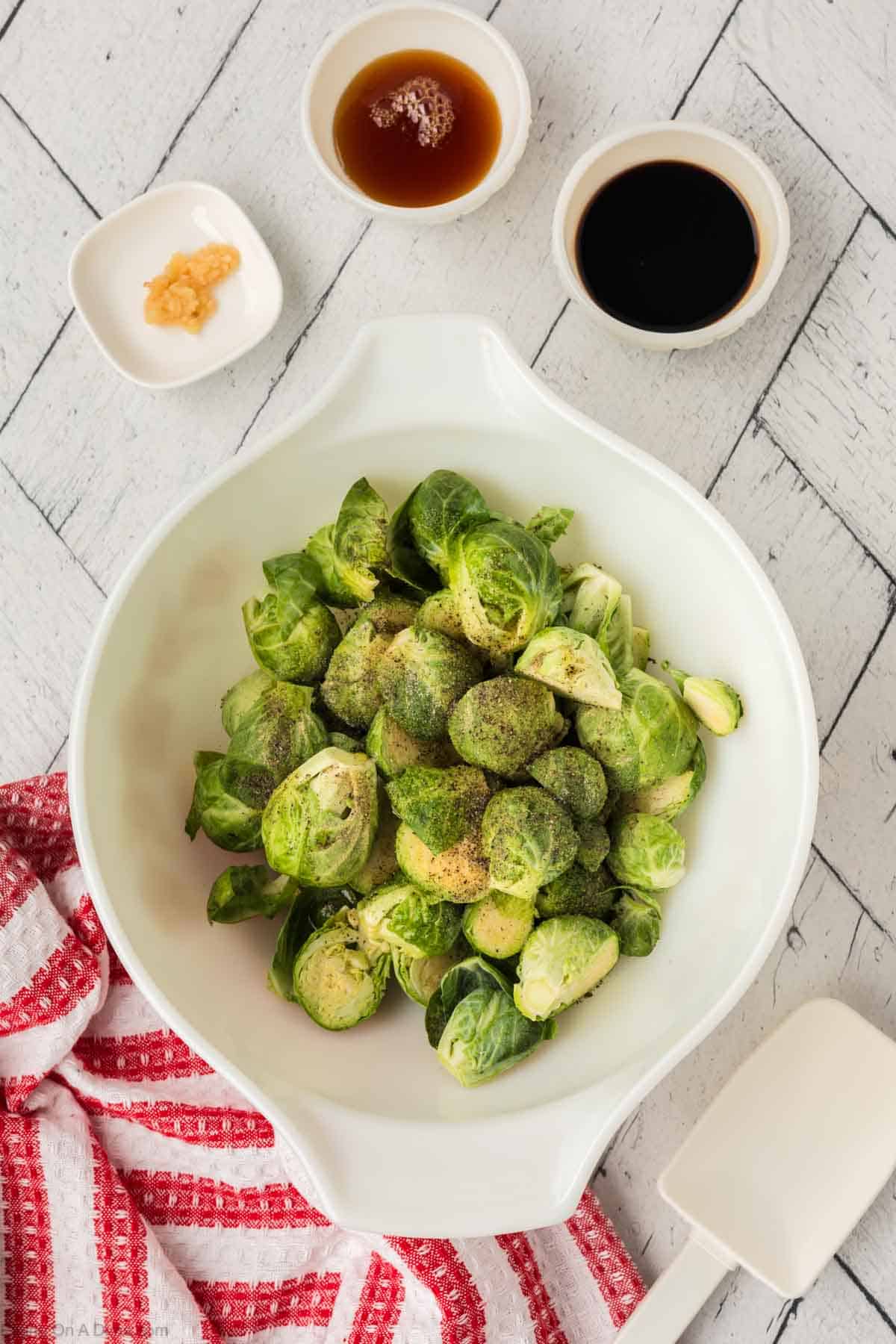 Fresh Brussel Sprouts in a bowl topped with salt and pepper