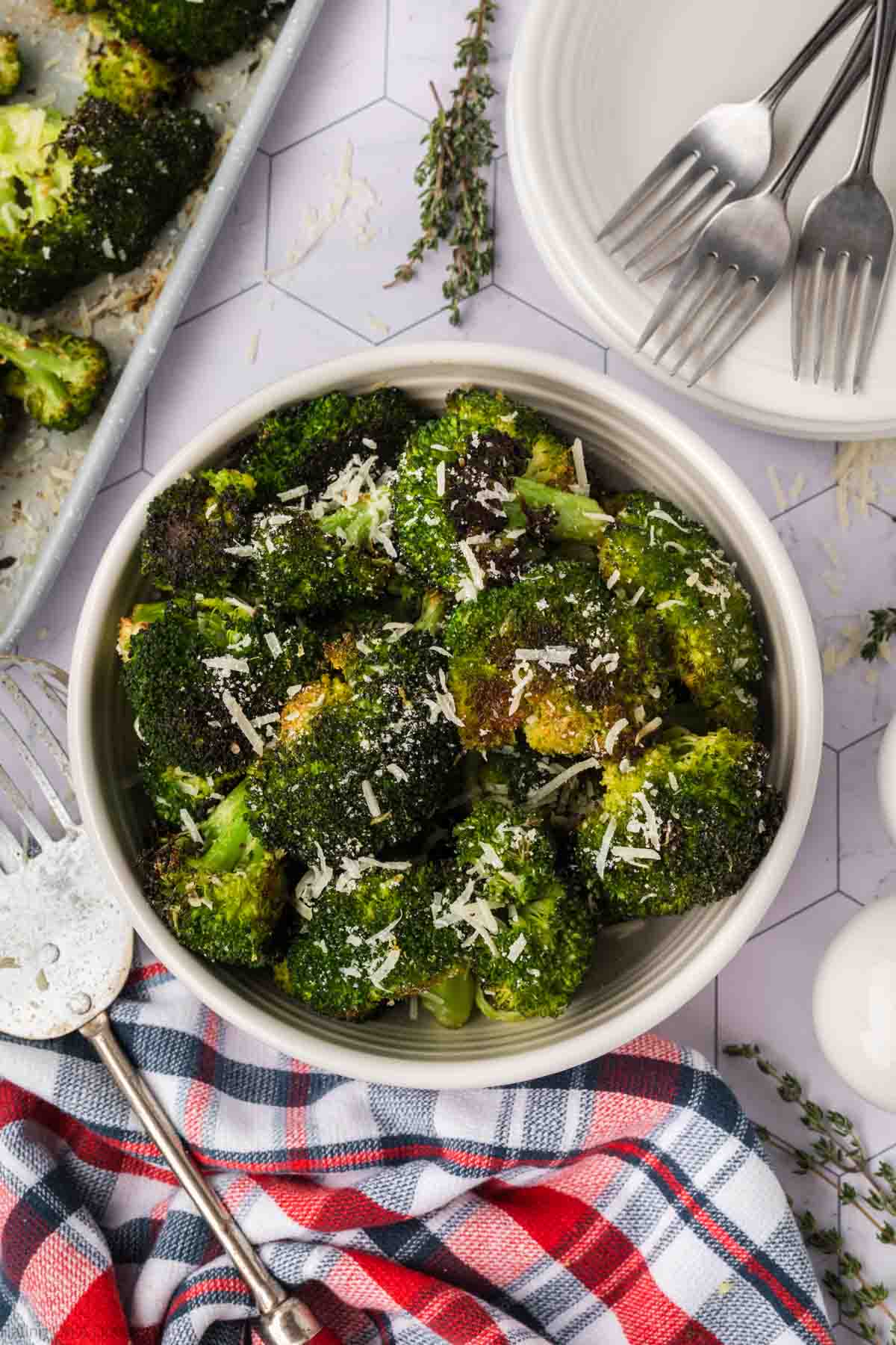 Roasted Broccoli in a bowl topped with shredded parmesan cheese