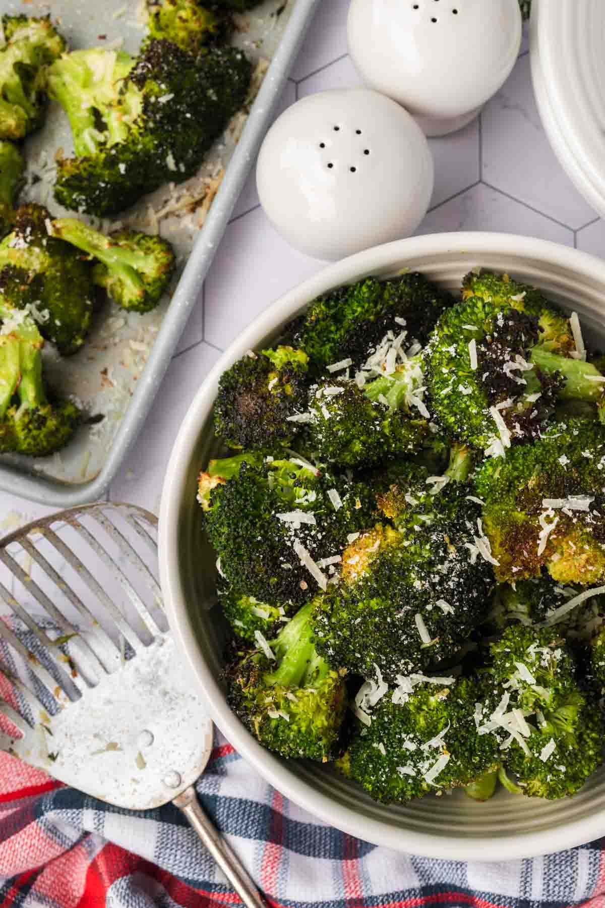 Roasted Broccoli in a bowl topped with shredded parmesan cheese