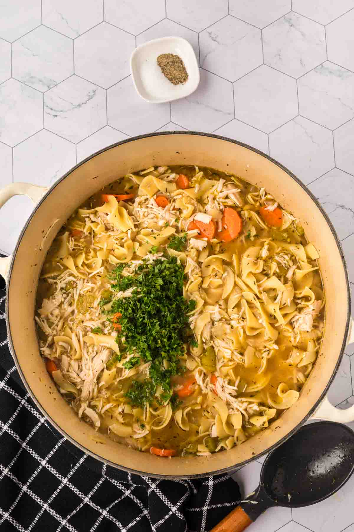 Turkey Noodle soup in a large pot topped with fresh parsley