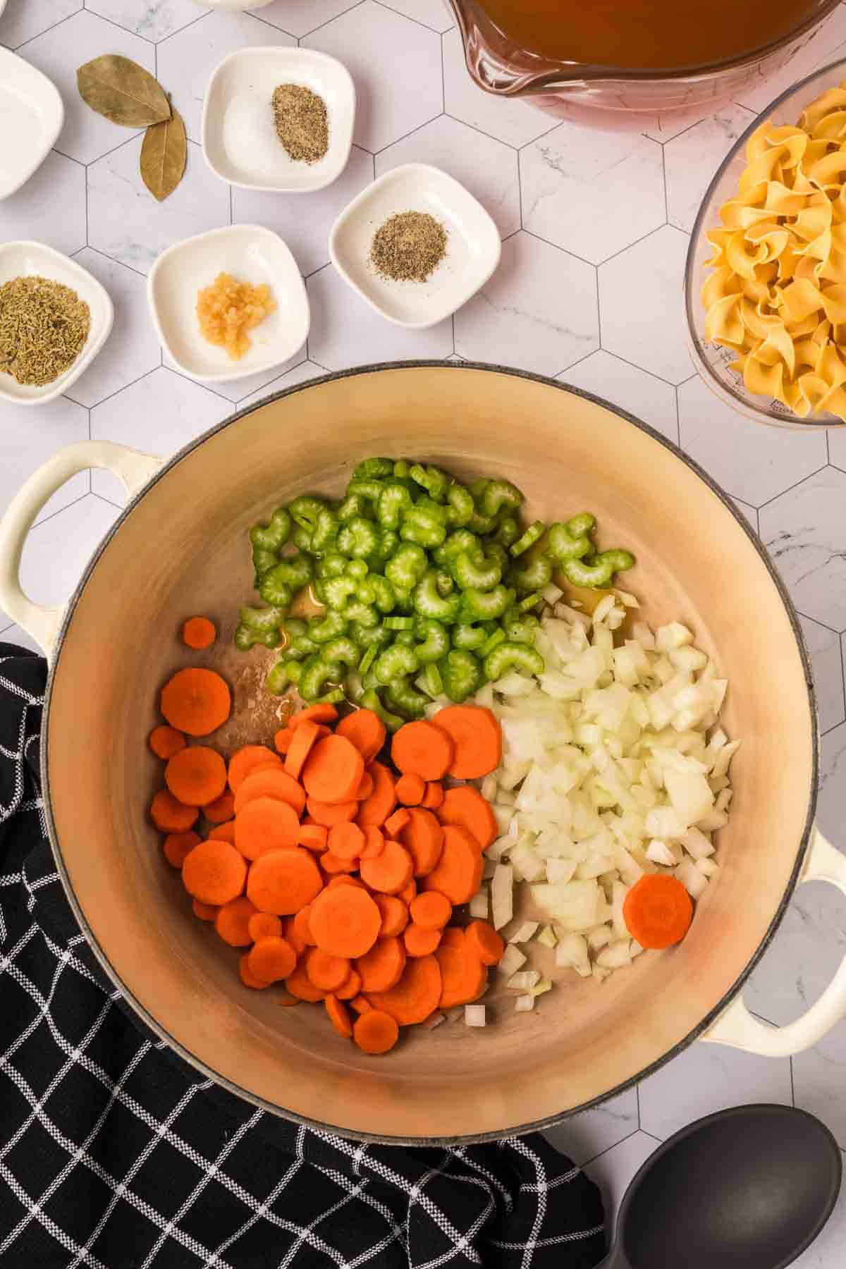 Slice celery, carrots and onions in a large pot with small bowls of spices and minced garlic on the side