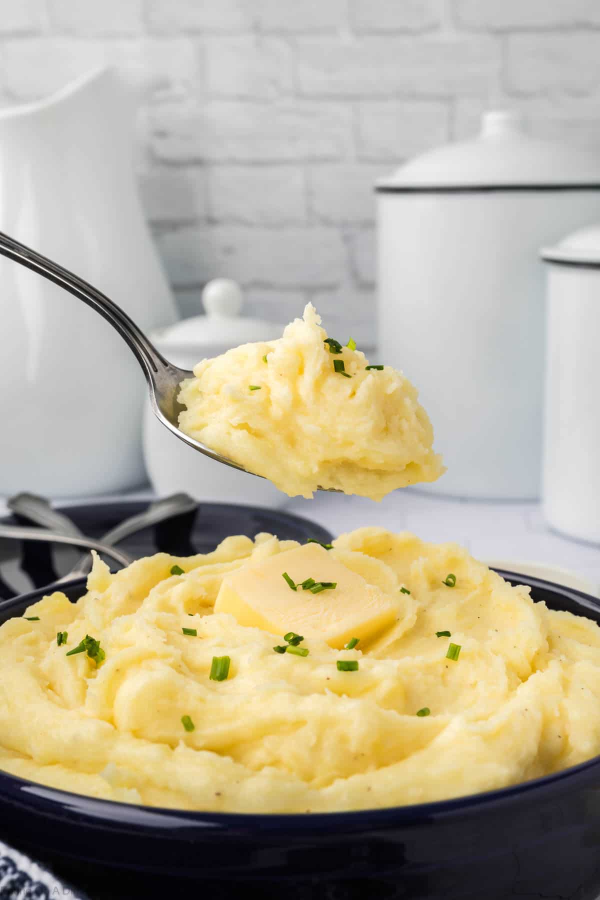 Yukon Gold Mashed Potatoes in a large bowl with a serving on a spoon