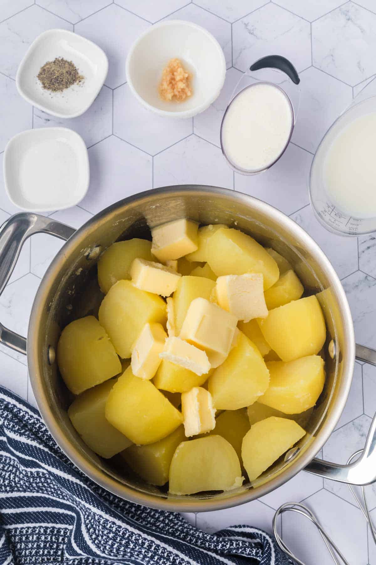 Cooked Yukon Gold Potatoes in a large pot with butter on top