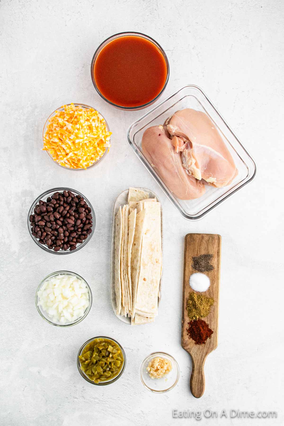 Ingredients - Boneless Chicken Breasts, black beans, red enchilada sauce, diced green chiles, onion, ground cumin, chili powder, salt, pepper, Mexican cheese blend, flour tortillas