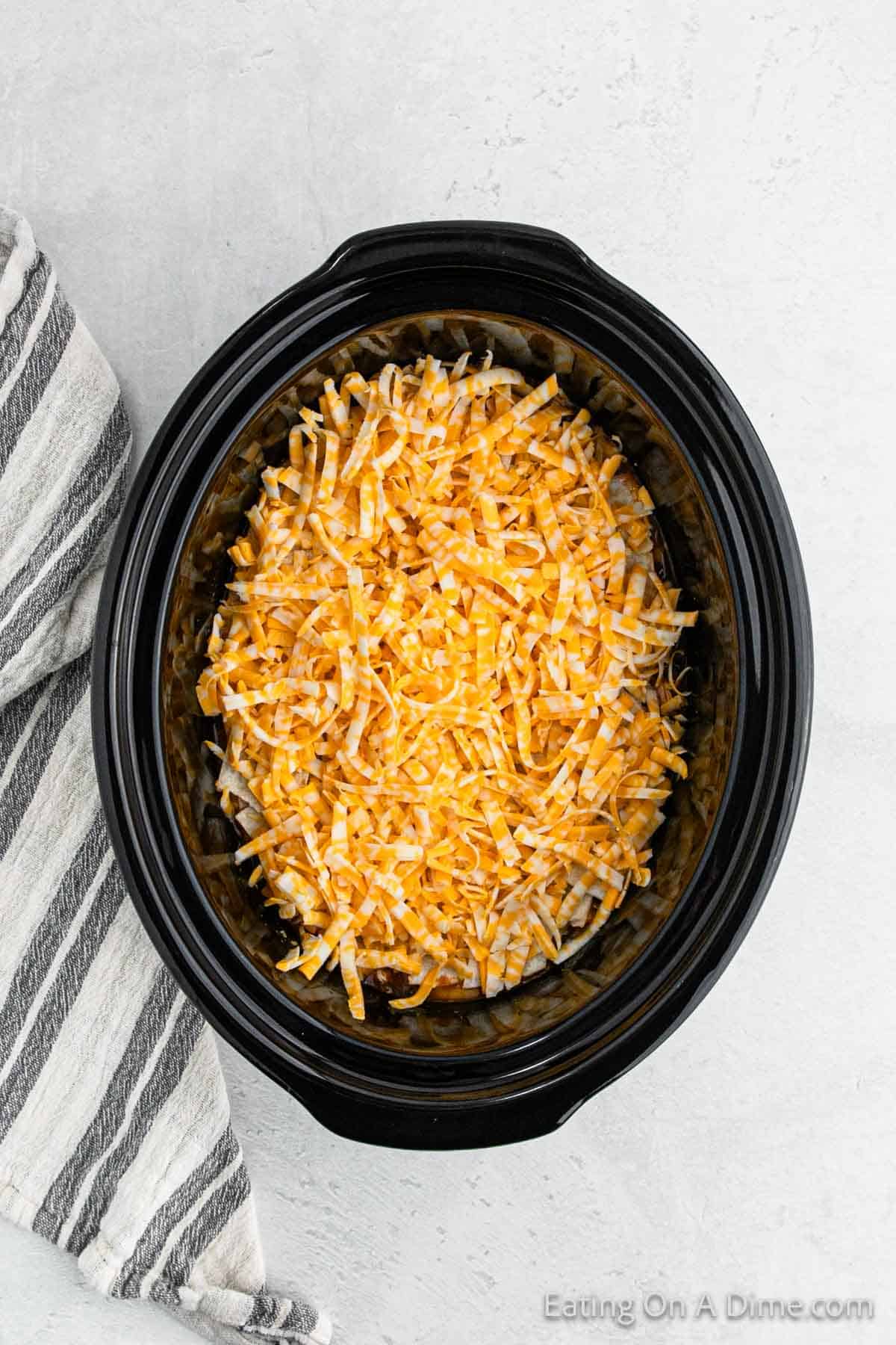 Shredded cheese topped the chicken enchilada mixture in the slow cooker