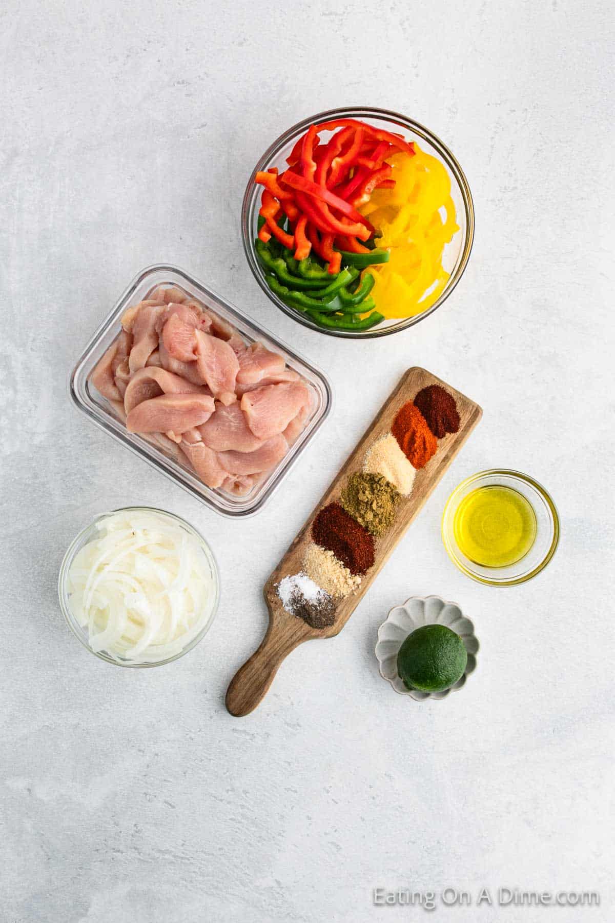 Fajita Ingredients - Chicken Breast, onion, red, yellow, green bell peppers, olive oil, lime, chili powder, cumin, paprika, salt, pepper, onion powder, garlic powder, cayenne pepper