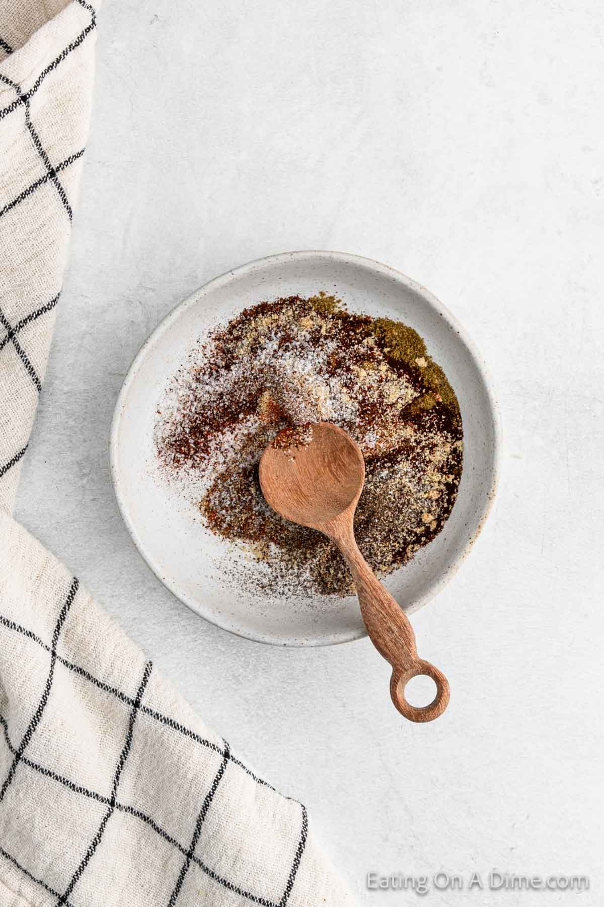 Combining the seasoning in a bowl with a wooden spoon